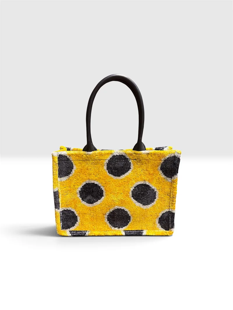 Kilim tote with charcoal dots on a saffron ground and rolled dark brown handles