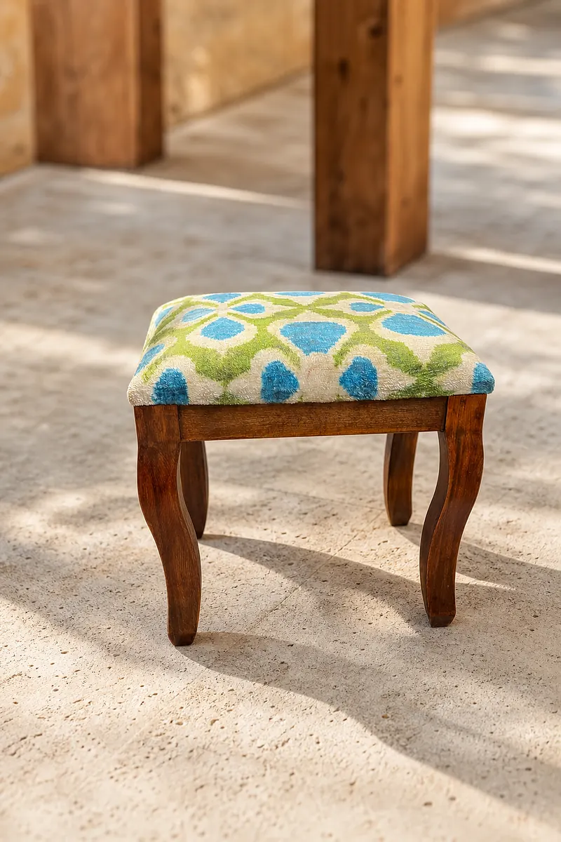 Kilim stool with a turquoise garden-lattice top on an oiled walnut cabriole frame, on travertine paving